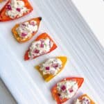 These roasted baby peppers stuffed with feta are a delicious and easy veggie appetizer for any party! I like to make them ahead and serve them cold for a fun finger food and simple crowd pleaser! Bite size and quick to make!