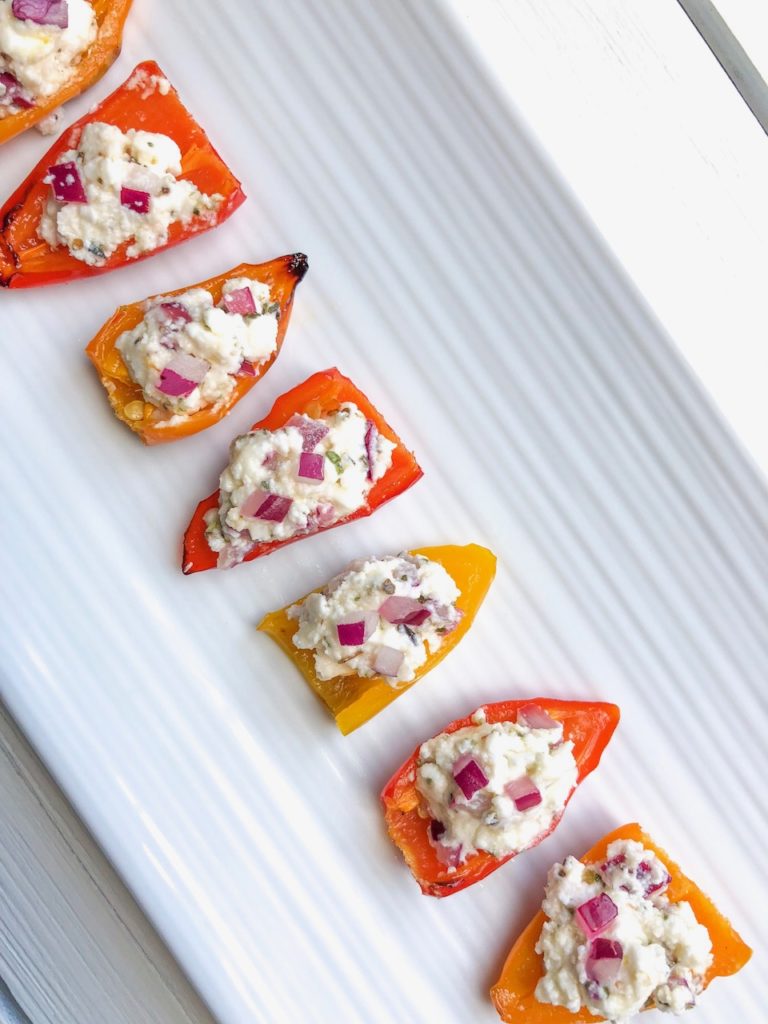 These roasted baby peppers stuffed with feta are a delicious and easy veggie appetizer for any party! I like to make them ahead and serve them cold for a fun finger food and simple crowd pleaser! Bite size and quick to make!