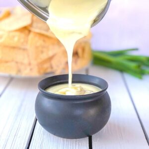 White cheese sauce being poured in a crock.