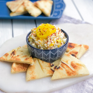 feta cheese dip in a bowl with pita bread