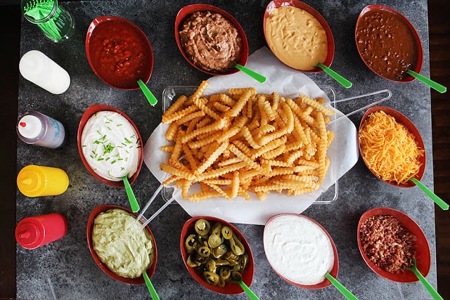 french fry bar with different toppings in bowls