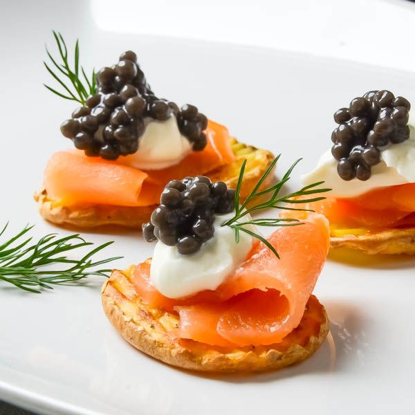 slices of salmon topped with a dollop of sour cream and caviar