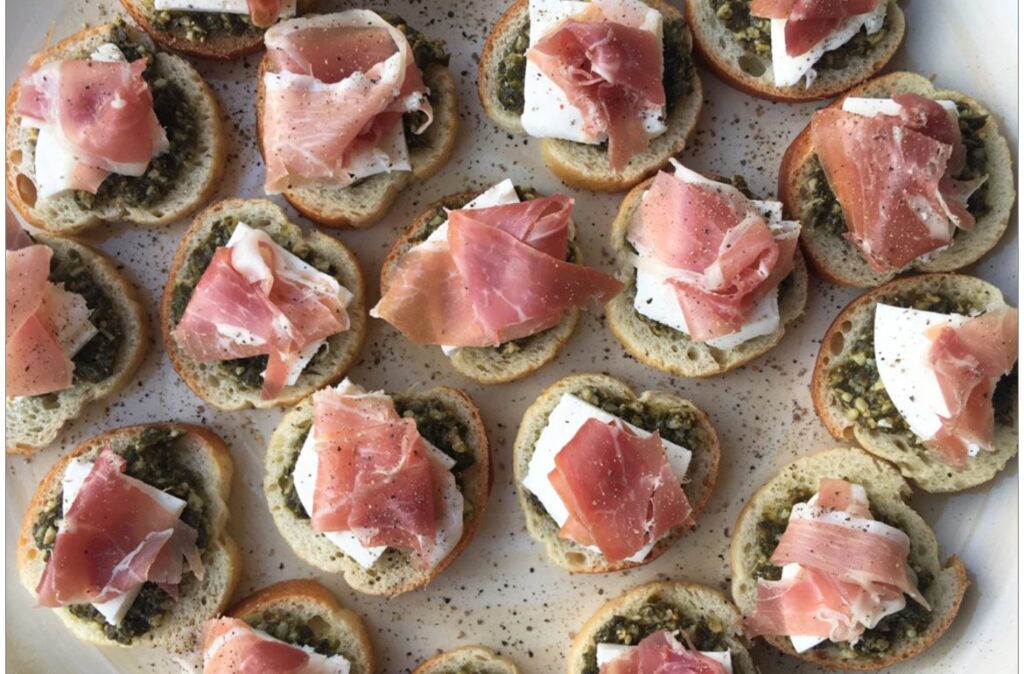 mini pesto crostini canapes topped with slices of pancetta
