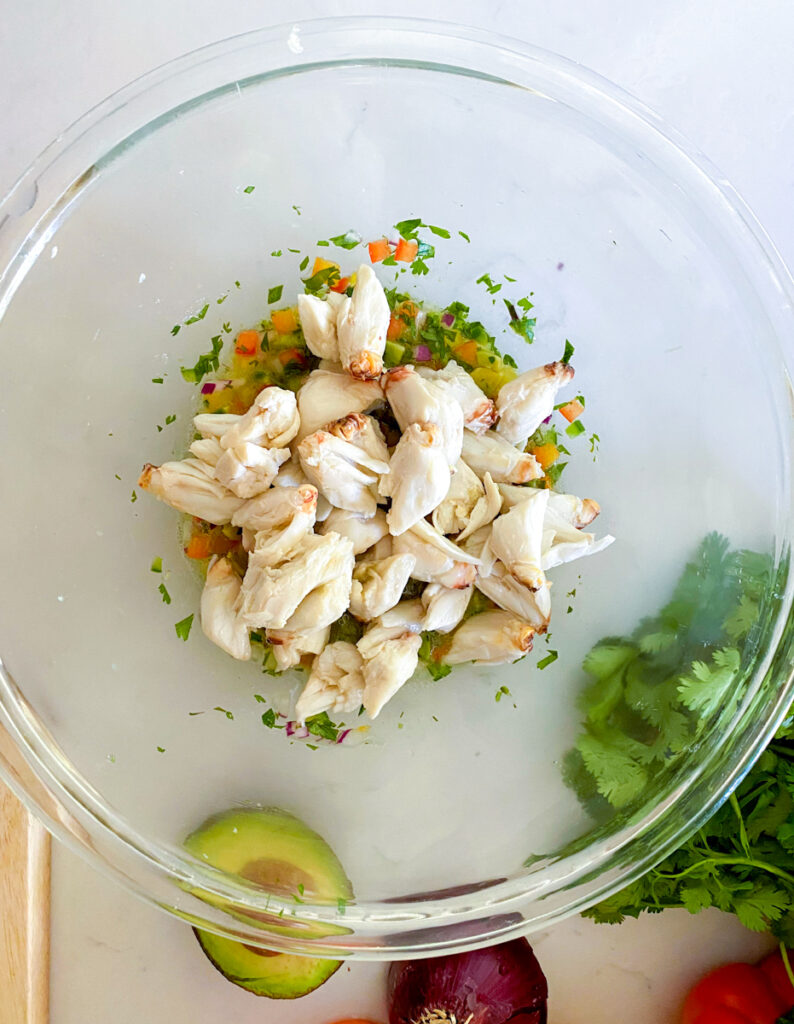 jumbo lumps of crab meat in a bowl with cilantro peppers onion and lemon juice