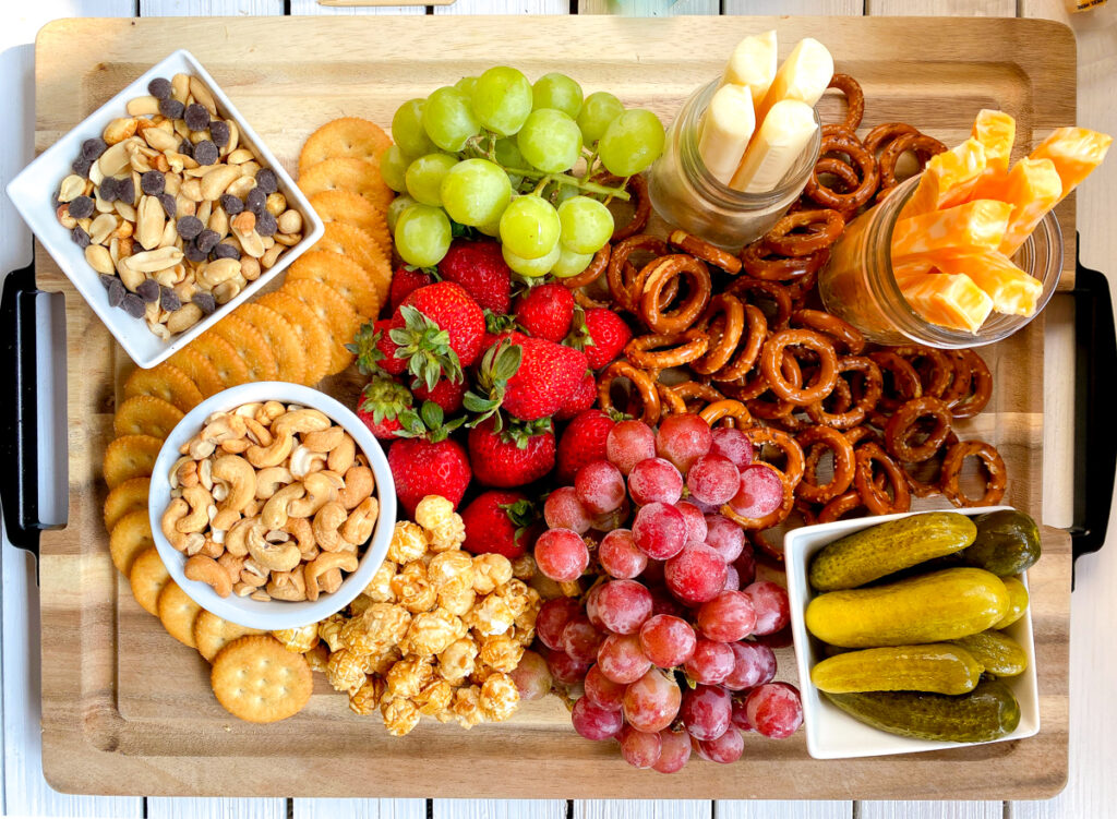 large charcuterie board for kids with cheese, nuts, fruit and snacks